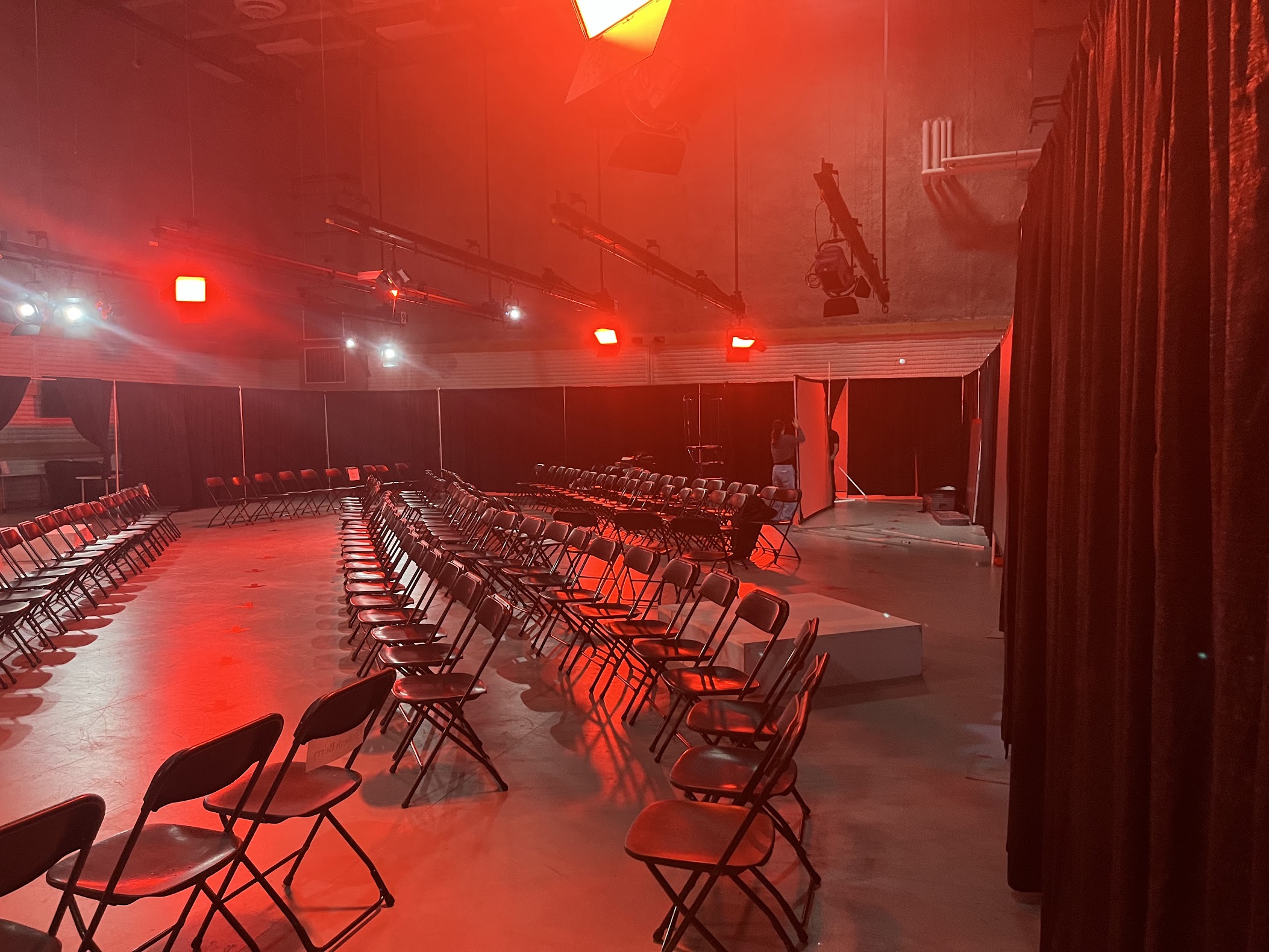The finished room: rows of chairs around the runway under red stage light